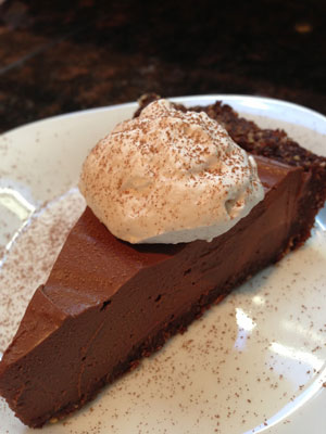 picture of a pie made of chocolate and topped with whipped cream