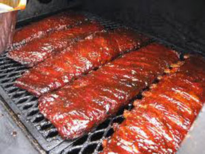 picture of spare ribs on a grill covered in sauce