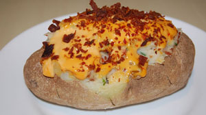 picture of a potato cooked with cheese and bacon on top