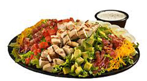 A large salad topped with grilled chicken and the usual toppings