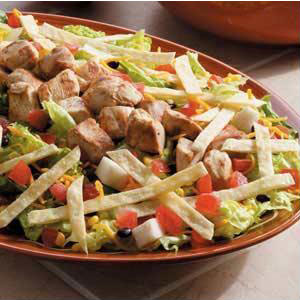 picture of a salad with chicken, tortilla strips, and corn bean mixture