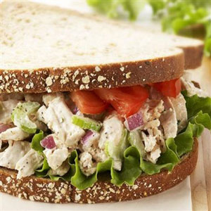 a picture of a sandwich with chicken salad on lettuce and tomato