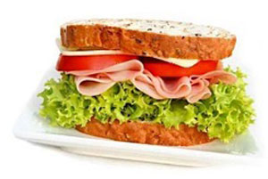 picture of a sandwich with ham, lettuce, tomato, and swiss