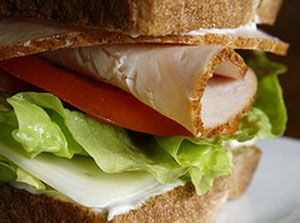 picture of a sandwich with turkey, lettuce, tomato, and swiss