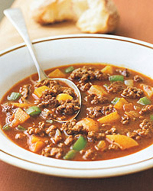 A picture of a bowl of soup with beef, potato, and an assortment of vegetables