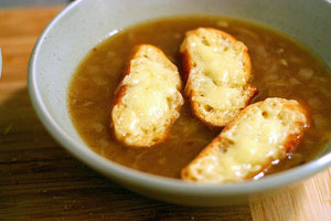 picture of a brown broth soup with onions and cheese bread